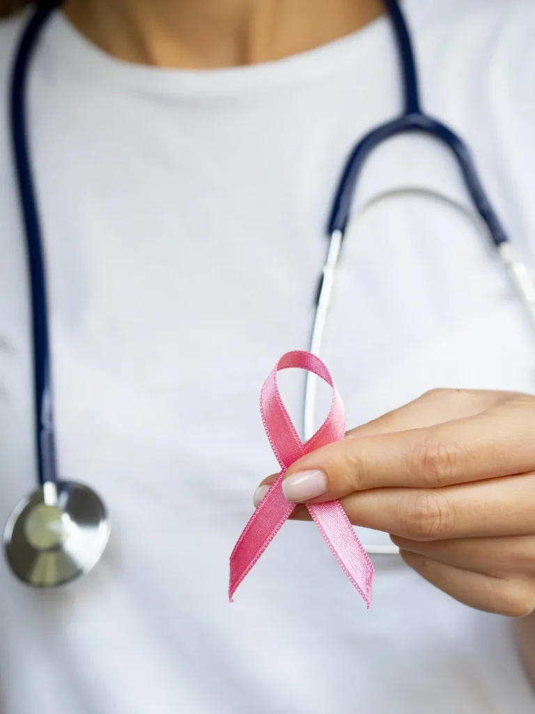 Mulher segura uma fita rosa e um estetoscópio em campanha sobre câncer de mama.