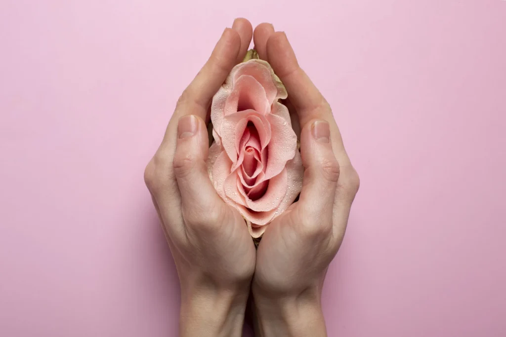 Mulher segura uma flor rosa próxima ao abdômen em campanha de prevenção.